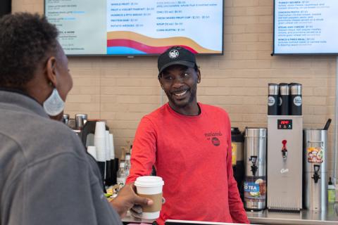 Barista smiling while serving a beverage