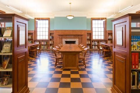 long wooden table with chairs in the middle of a large room