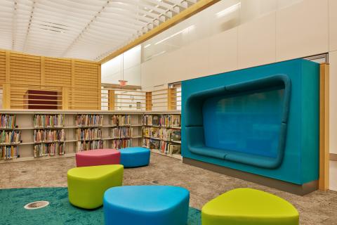 children's room with bright geometric seating cushions and low bookshelves