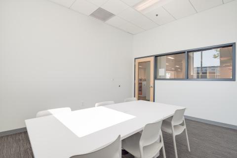 sunlit meeting room with table and six chairs