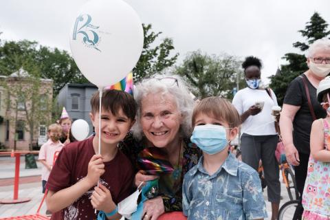 older woman smiles next to two young boys