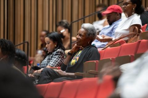 older women sits attentive in the audience