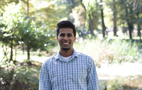 Picture of a young man dressed professionally starting in a park