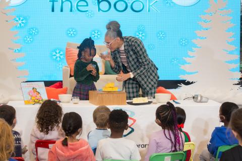 Woman and child host cooking demonstration in front of little kids