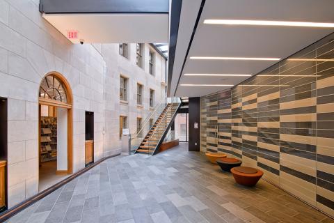 stairwell in the middle of the room with a wall on one side and arched doors on the other