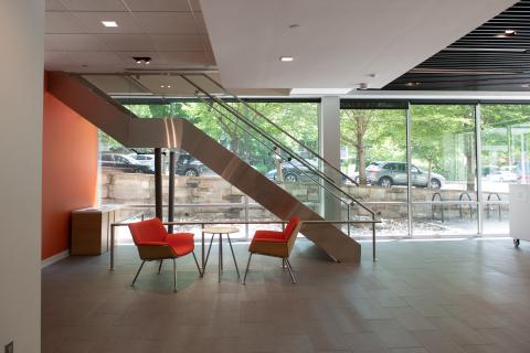 stairwell going up with orange chairs at the base