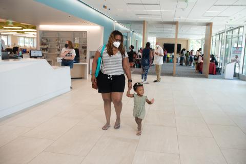 Mother and baby walk across the front desk area