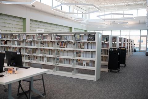 room with book stacks and tables with computers
