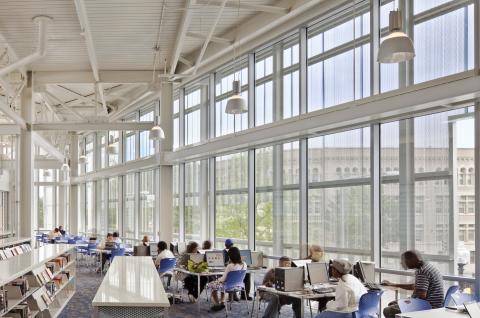 overview of main room with low bookshelves and people seated at various tables