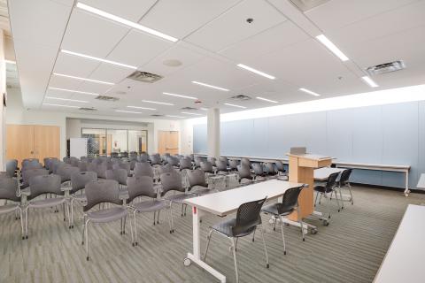 Room set up lecture style with a podium and classroom seating