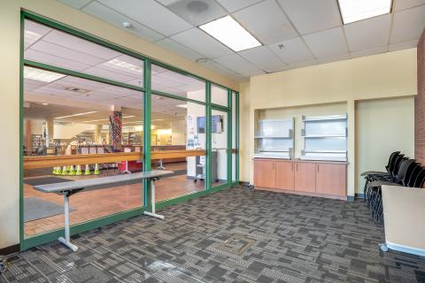 large empty room with glass wall looking into main library room