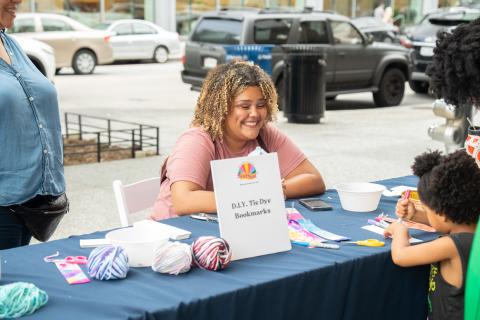Woman at table smiles at little girl