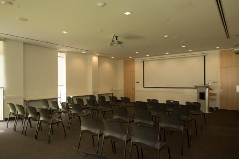 Room set up lecture style with a podium and classroom seating
