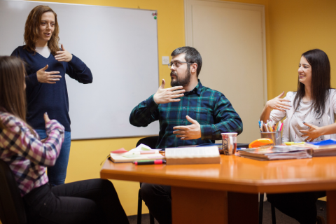 A teacher showing a classroom how to sign in American Sign Language. 