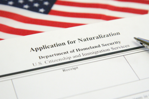 application for naturalization sits on an American flag