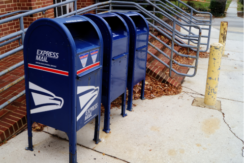 three blue express mail post office mail boxes on a sidewalk